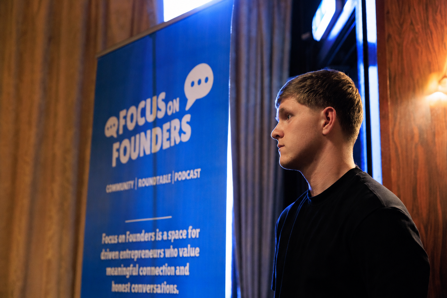 Matthew Adams, founder of Focus on Founders, beside the brand banner at a Glasgow event